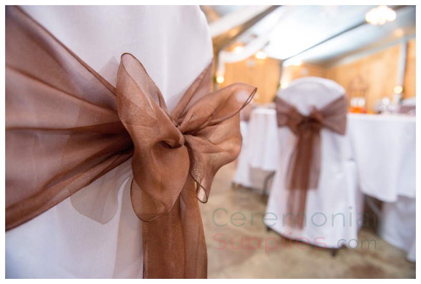 brown bow on white chair cover