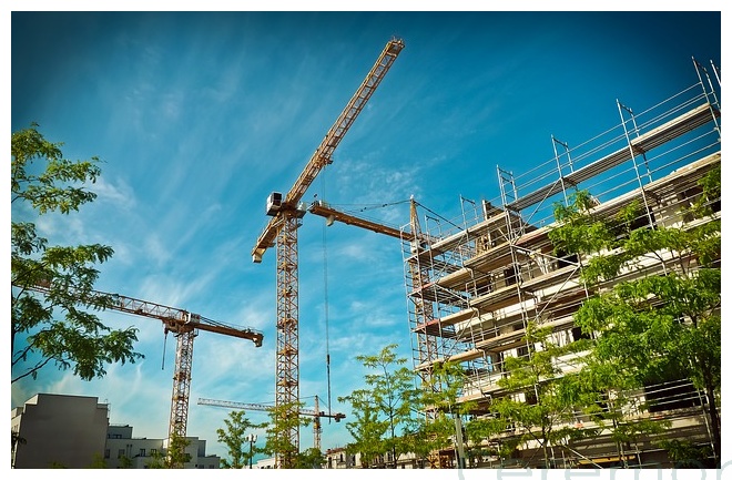 cranes with buildings under construction daytime