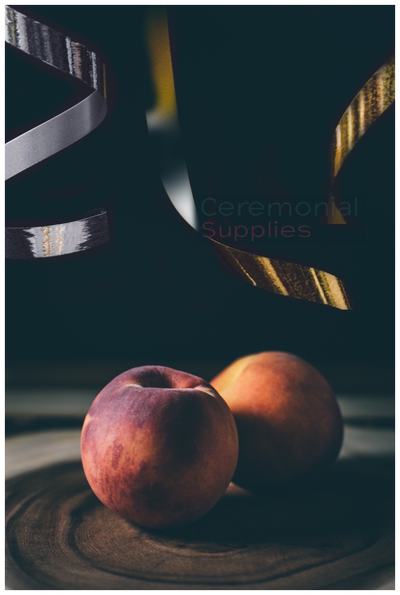 two juicy peaches with gold and silver ribbons above