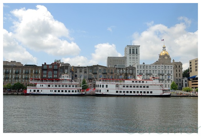 two riverboats with city of Savannah in background