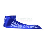 Grand opening ribbon in royal blue showing printed message.