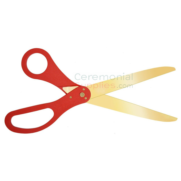 Image of golden blade scissors with red handles.