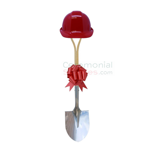 Upright view of red groundbreaking shovel, hard hat and bow kit.