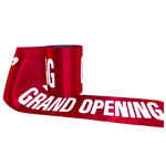 Roll of red grand opening ribbon displaying printed text.